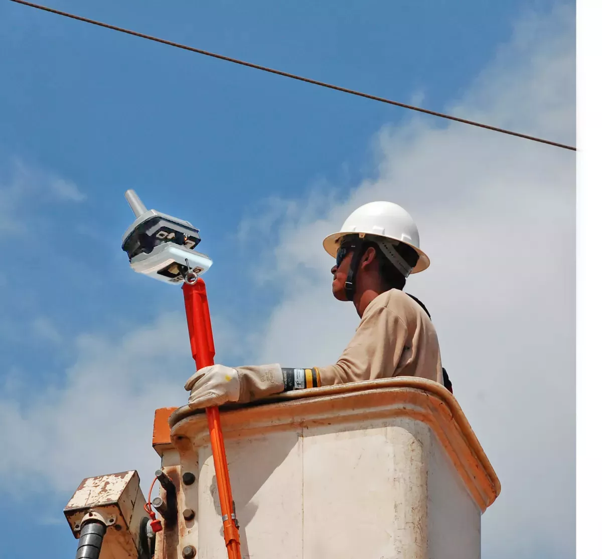 Engineer installing a grid sensor for electrical grid diagnostics with data sent to MGA smart grid analytics software